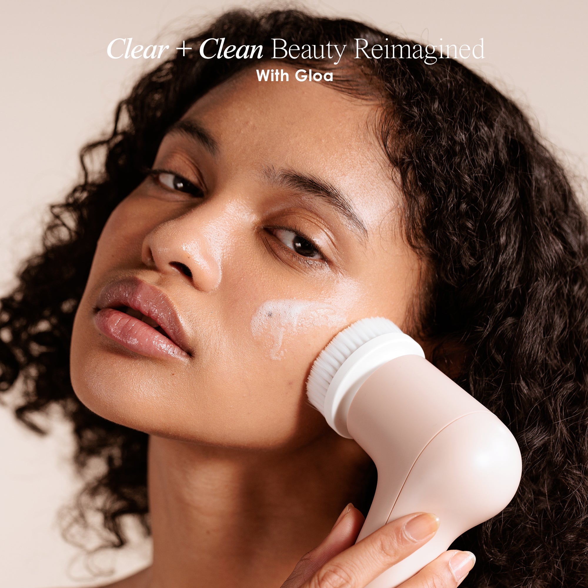 Gloa face and body cleansing brush showing a model using the device